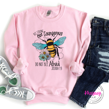 Pink sweatshirt with bee graphic and text, paired with jeans and sneakers on a white background.