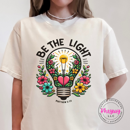 Ivory tee featuring a colorful flower-filled lightbulb faith graphic
