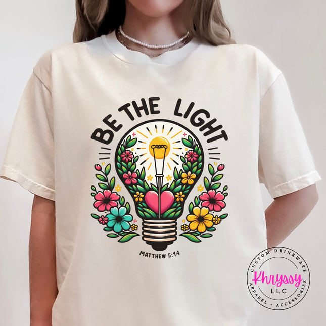 Ivory tee featuring a colorful flower-filled lightbulb faith graphic