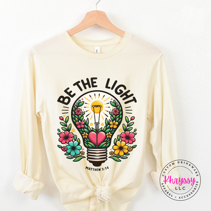 Natural long sleeve tee showing a blooming lightbulb and Matthew verse