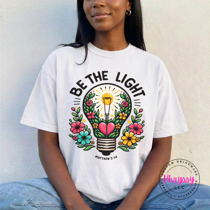 White tee with a bright floral lightbulb and Be The Light design