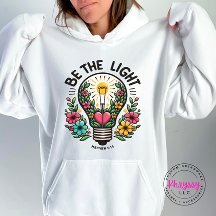 White hoodie with a bright floral lightbulb and Be The Light faith design
