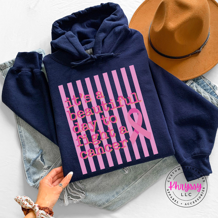 Navy hoodie hanging on a rack showing the beautiful day to fight cancer ribbon design