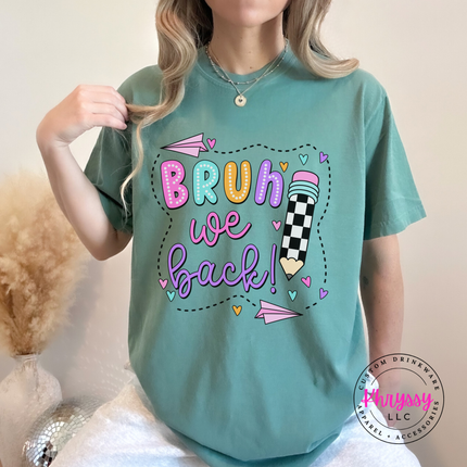 Smiling teacher in a light green tee with a pastel Bruh We Back design.