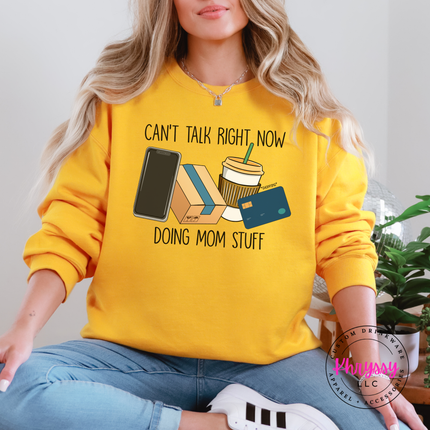 Gold crewneck sweatshirt featuring the funny doing mom stuff design with iced coffee