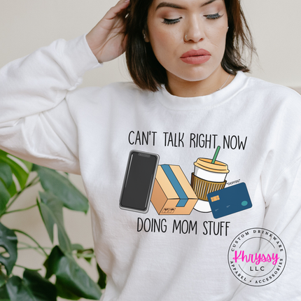 White crewneck sweatshirt with the can't talk right now doing mom stuff design
