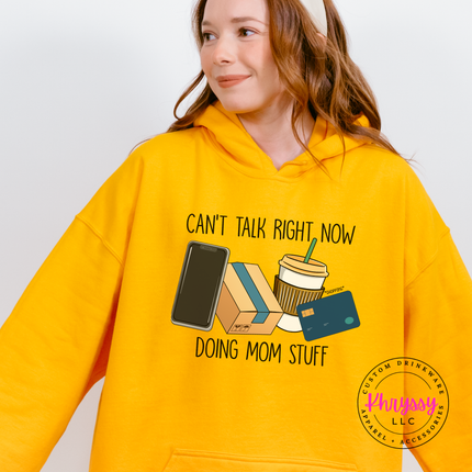 Gold hoodie with the doing mom stuff design of coffee, phone and packages