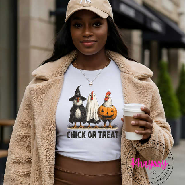 Woman wearing a 'Chick or Treat' shirt with cartoon characters, holding a coffee cup outdoors.