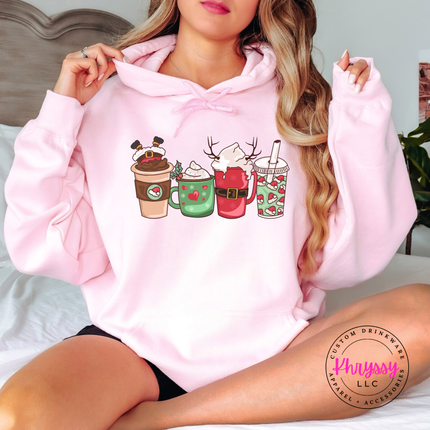 Woman wearing the Christmas coffee cups hoodie in Light Pink.