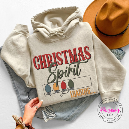 Close up of the Christmas Spirit Loading art on a Sand hoodie.