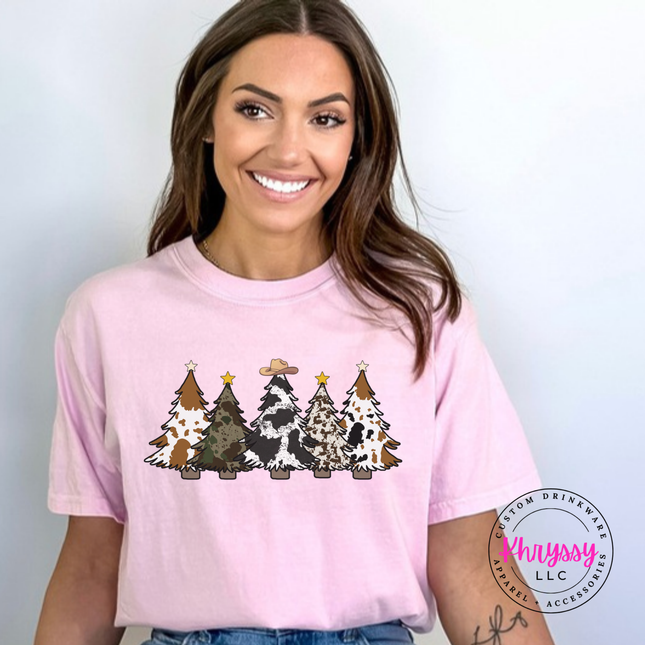Blossom tee featuring five cow print and leopard Christmas trees.