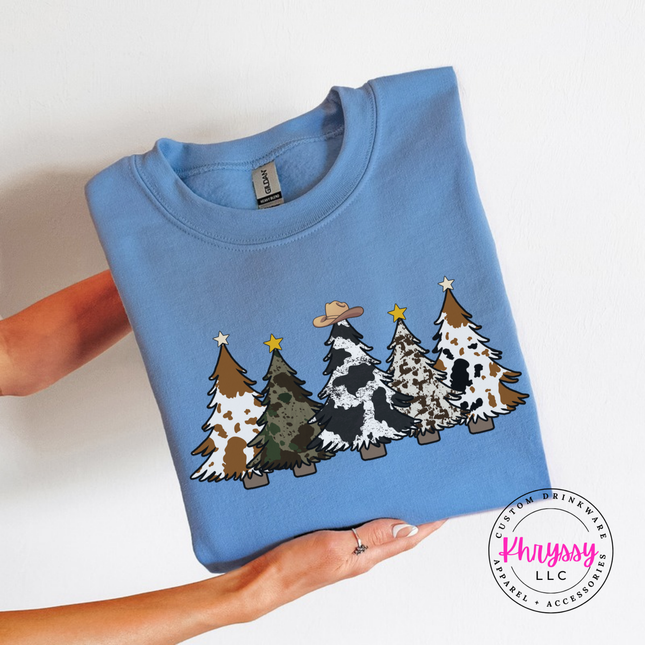 Model wearing the cow print trees crewneck sweatshirt in Carolina Blue.