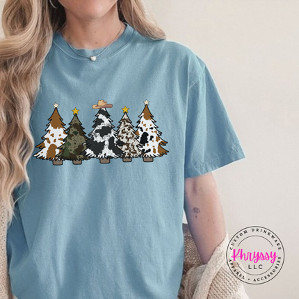 Ice Blue tee featuring five cow print and leopard Christmas trees.
