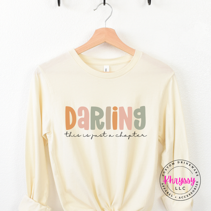Natural long sleeve tee featuring a just-a-chapter script reminder