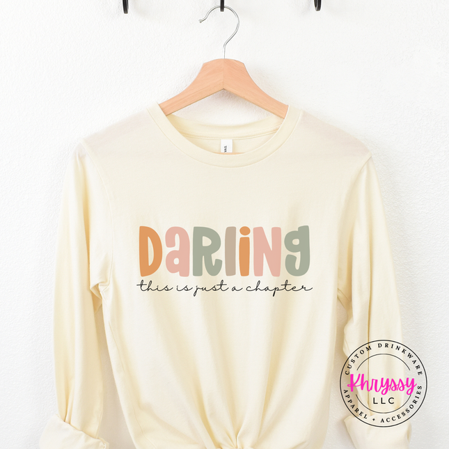 Natural long sleeve tee featuring a just-a-chapter script reminder