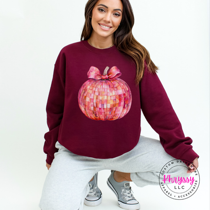 Maroon crewneck sweatshirt featuring a pink mosaic disco pumpkin illustration.