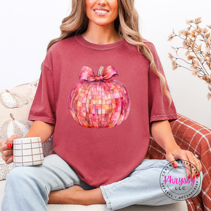Woman wearing a Brick colored tee with a pink mosaic disco pumpkin.