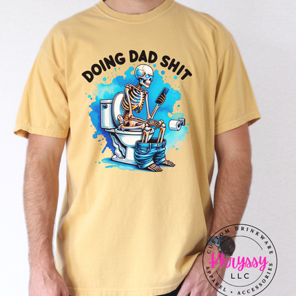 Yellow t-shirt with skeleton graphic and text 'Doing Dad Shit' worn by a person, brand logo visible.