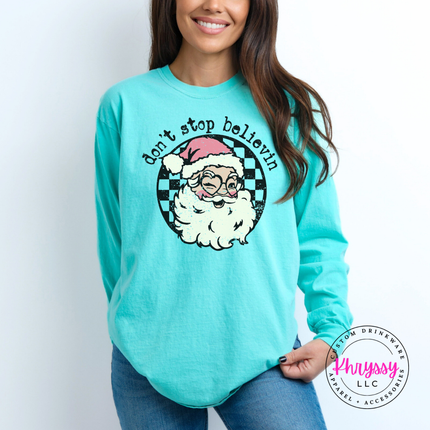 Model wearing the retro believing Santa long sleeve tee in Chalky Mint.