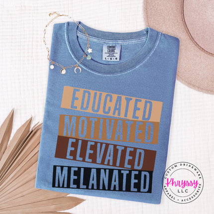 Blue Jean Comfort Colors tee with bold gold brown black stacked bar Educated Motivated Elevated Melanated print.