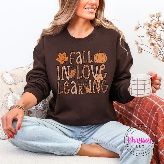 Woman wearing an Dark Chocolate crewneck sweatshirt with a Fall In Love design.