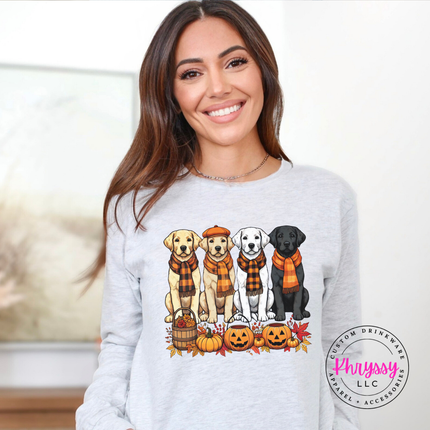 Woman wearing an Ash Bella+Canvas long sleeve with a fall labrador puppies graphic.