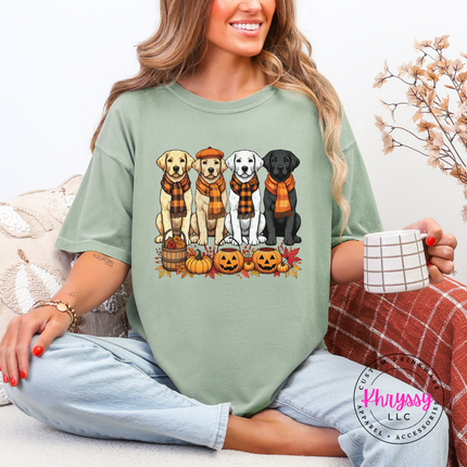 Woman wearing a Bay Comfort Colors tee with a fall labrador puppies graphic.