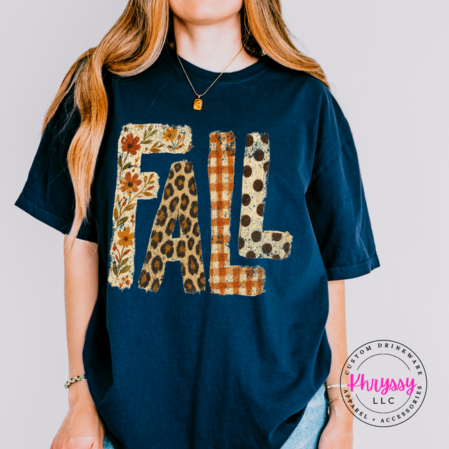True navy tee with FALL lettering filled in leopard, plaid, and floral print.