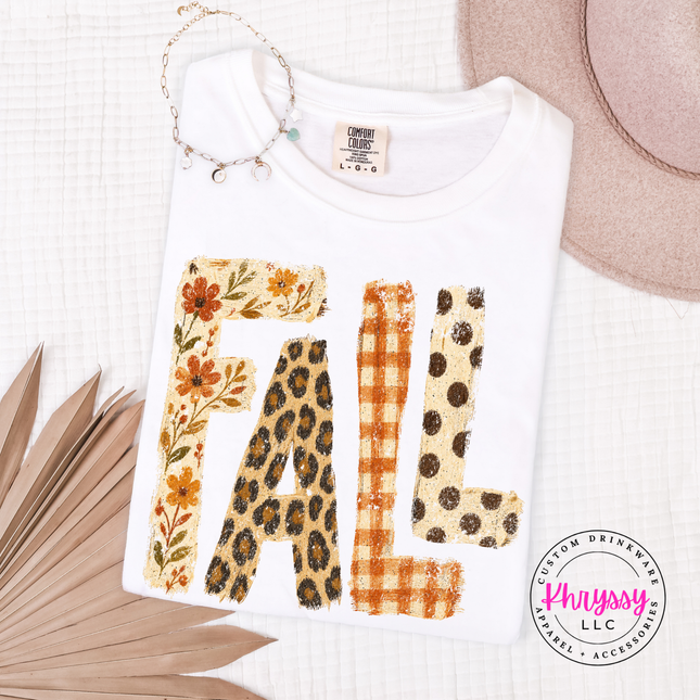 White shirt featuring autumn-patterned FALL text design.