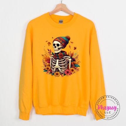 Gold colored crewneck sweatshirt featuring a cozy skeleton in a beanie.