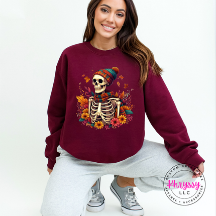 Maroon crewneck sweatshirt with a hand-illustrated fall skeleton and floral design.