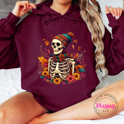 Maroon hoodie with the cozy fall skeleton in a beanie graphic