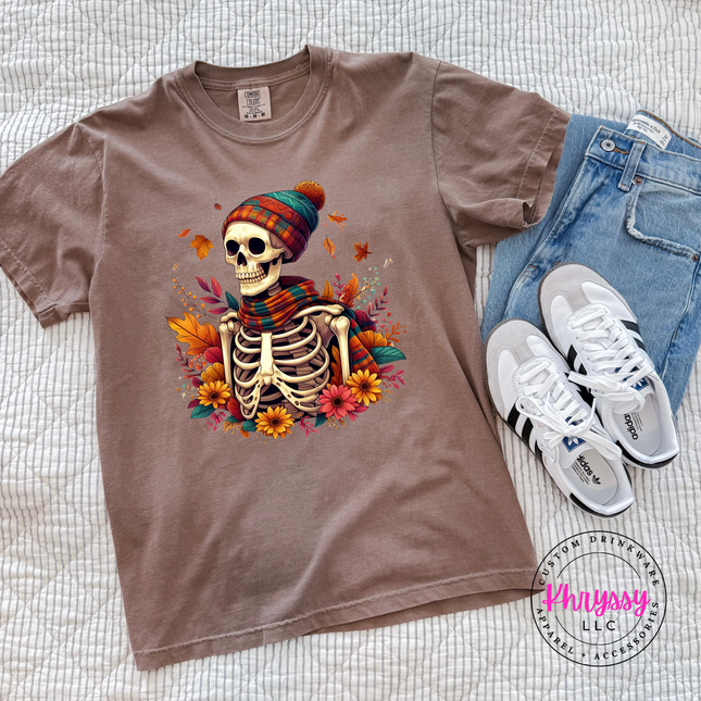  Espresso colored tee featuring a scarf-wearing skeleton among rust and teal florals.