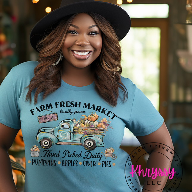 Woman wearing a blue t-shirt with a farm-themed design and 'Khrysy' branding.