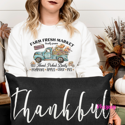 Woman wearing a White crewneck sweatshirt with a truck design.