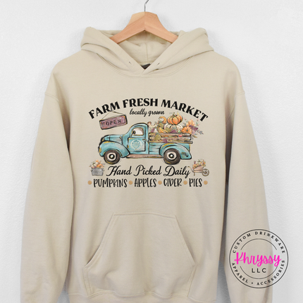 Woman wearing a Sand pullover hoodie with a truck design.