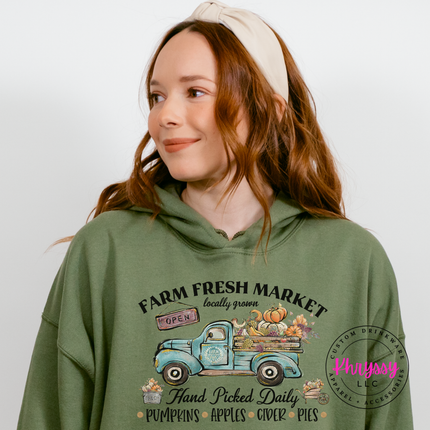 Military green hoodie featuring pumpkins and apples loaded on a truck.