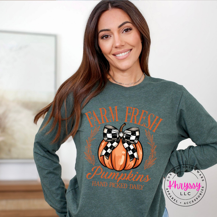 Woman wearing a heather forest tee with a farm fresh pumpkin design.