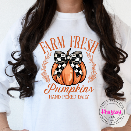 White crewneck sweatshirt featuring a checkered bow pumpkin.
