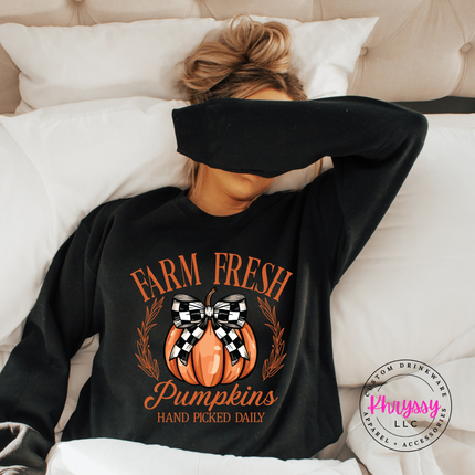 black crewneck sweatshirt with a hand-illustrated pumpkin graphic.