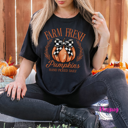Woman wearing a Black tee with the Farm Fresh Pumpkins hand picked daily graphic