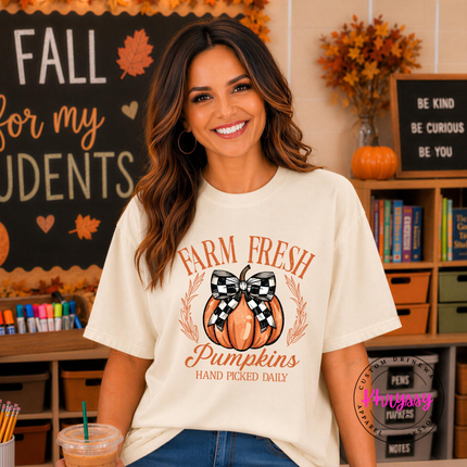 Ivory graphic tee featuring a checkered bow pumpkin illustration.