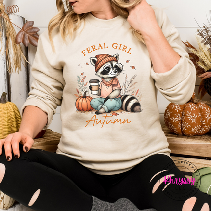 Sand colored crewneck sweatshirt featuring a feral girl autumn raccoon.