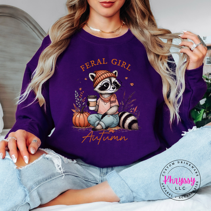 Purple crewneck sweatshirt with the Feral Girl Autumn raccoon graphic