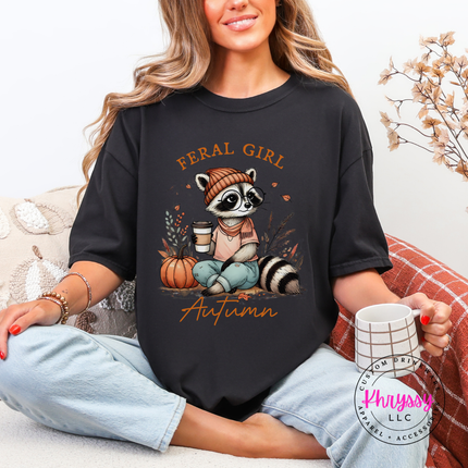 Woman wearing a Black graphic tee with a feral girl raccoon design.