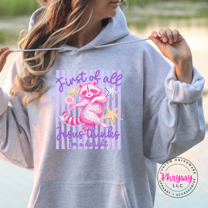 Gray hoodie with a colorful graphic and text held by a person outdoors.