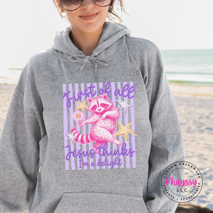 Person wearing a gray hoodie with a colorful graphic and text on a beach.