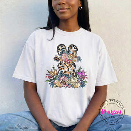 White garment-dyed tee displaying a leopard floral Easter bunny graphic.