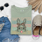 Sage soft cotton tee with a leopard-bandana bunny blowing a pink bubble.