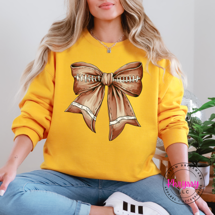 Close-up of a football lace bow graphic on a Gold crewneck.